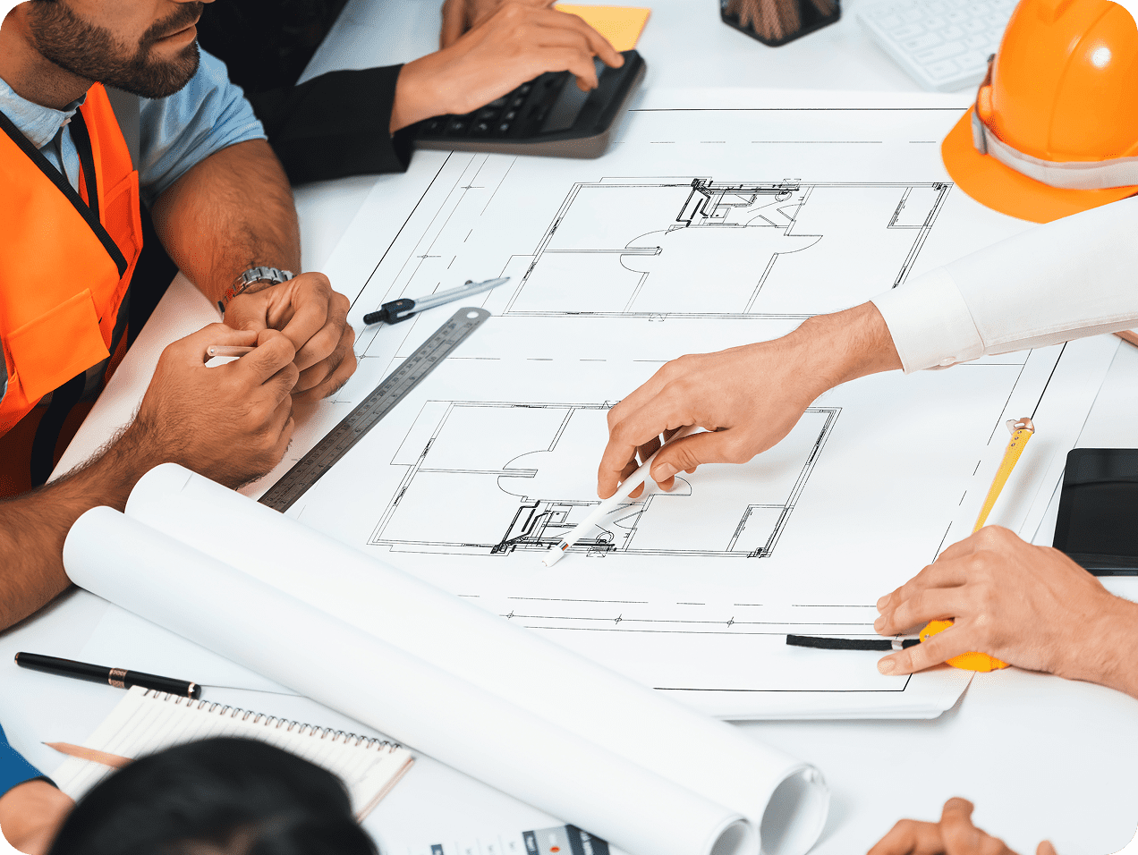 Architects discussing building plans at table.
